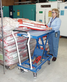 Woman loading bags of materials.