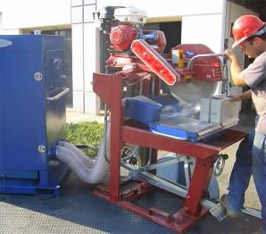 Worker cutting concrete block while using local ventilation