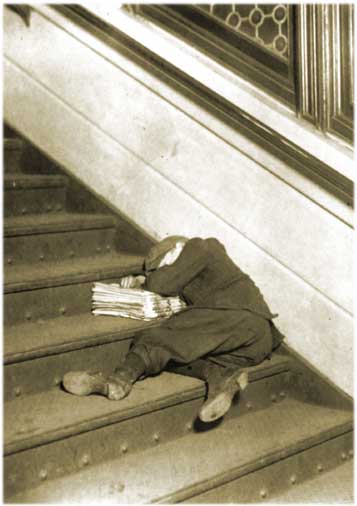 Photo of a little newspaper boy slept on stairs, taken in the US in the early 20th century.