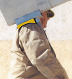 Laborer carrying a hog that is padded on the shoulder