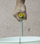 A hand holding a bucket handle with a bigger diameter handle