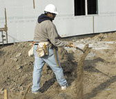 Laborer twisting back while shoveling