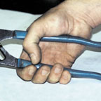 A hand holding a longer handle tool