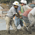 Laborer pausing between shoveling of concrete