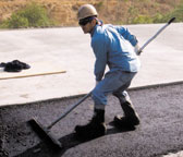 Laborer raking asphalt