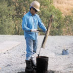 Laborer cleaning asphalt rake