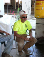 Man sitting down and drinking water in shaded area