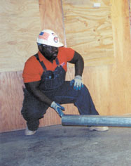 Two carpenters lifting a heavy beam together