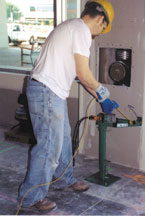 Carpenter keeping the drill close to his body