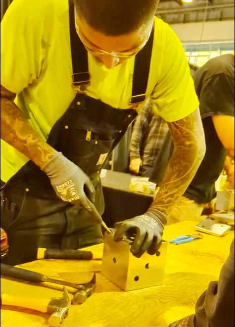 A student assembles a metal cube during a hands-on activity at Trades Day