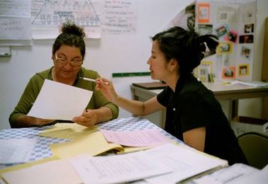 Staff and constituent at desk with paperwork