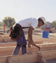 Carpenter bending over to pound nails
