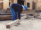 Carpenter lifting a heavy beam by himself