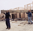Two carpenters lifting a heavy beam together