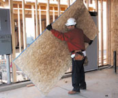 Laborer tilting plywood to one end