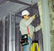 Carpenter keeping the drill close to his body