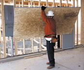 Laborer lifting plywood
