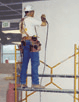 Carpenter using a scaffold to work on high area