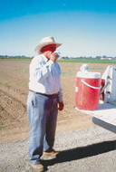 Man drinking water with a large hat on