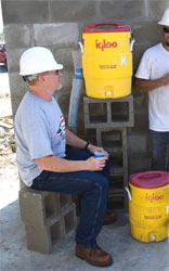 Man sitting in shade drinking water