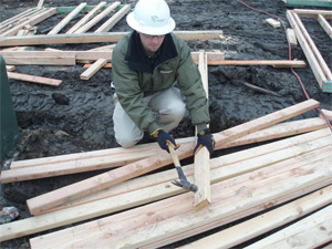 Man cleaning up scrap lumber.